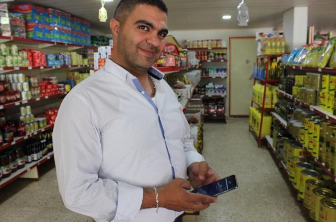Omar, a shop owner, makes his store more attractive with Dalili