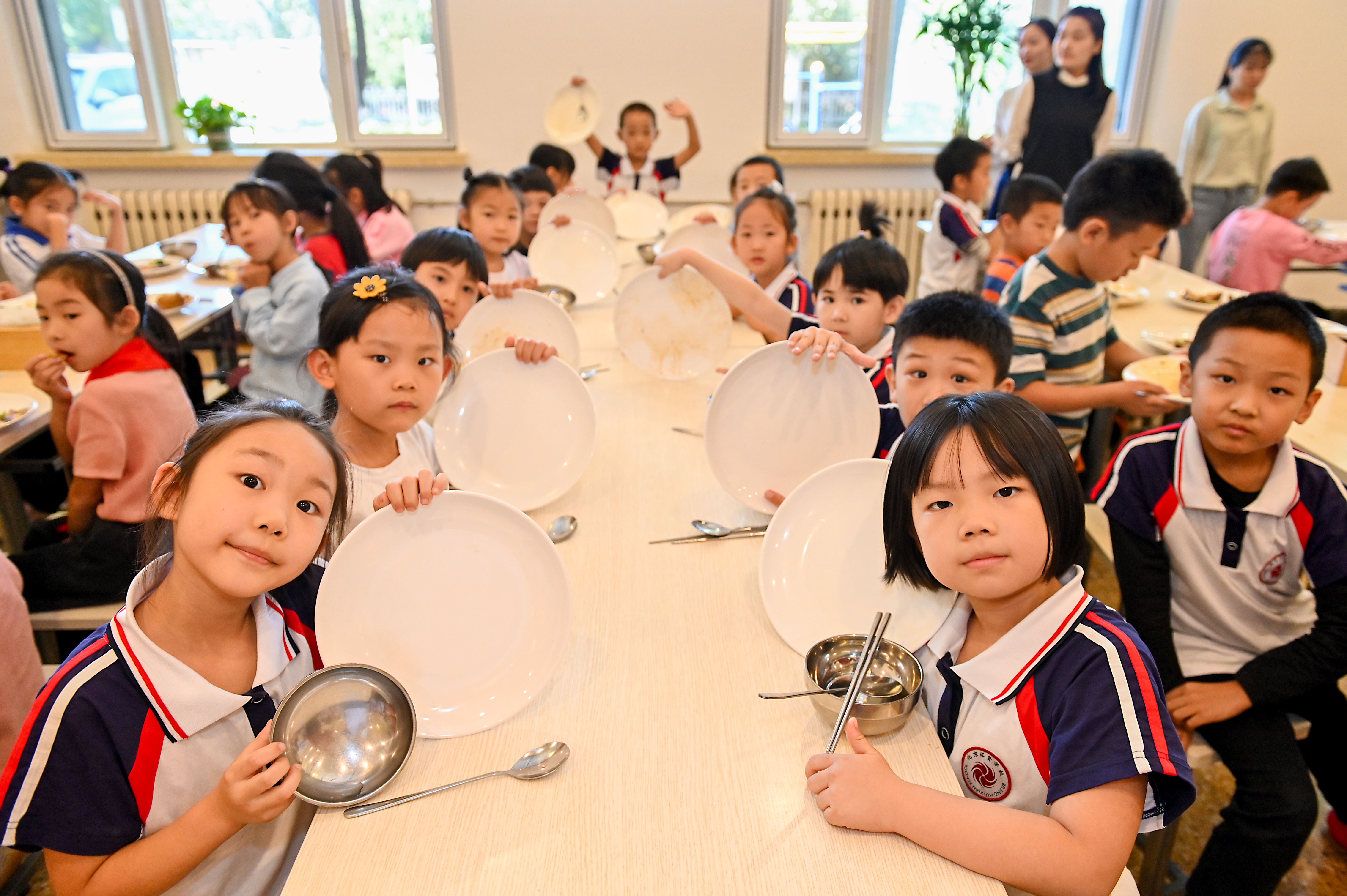 Children holding up clean plates; ​​Photo: WFP/Clear Plate