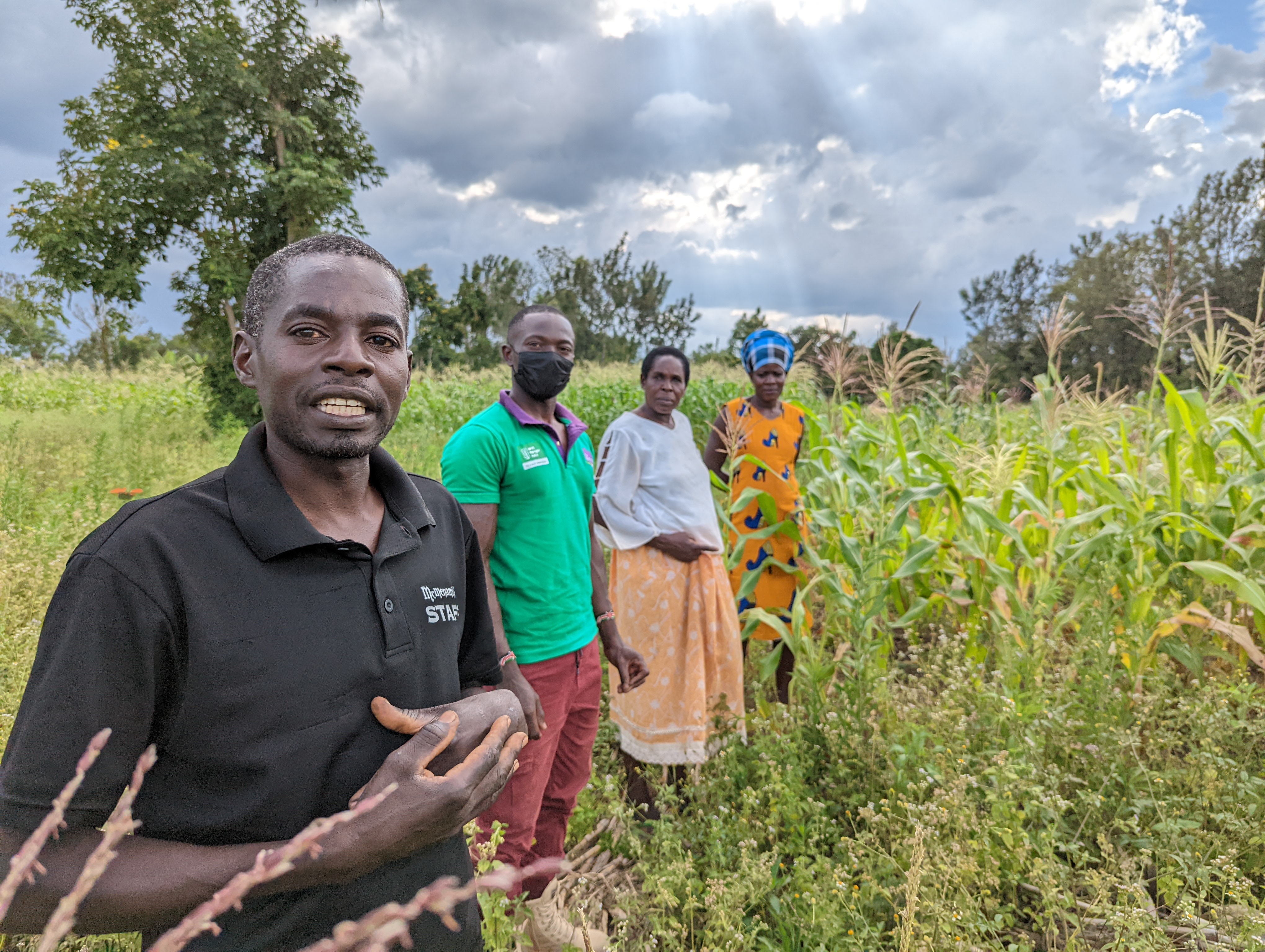 Farmers standing in the middle of a field. Photo: WFP/Claire Baker and Dorcas Kemboi