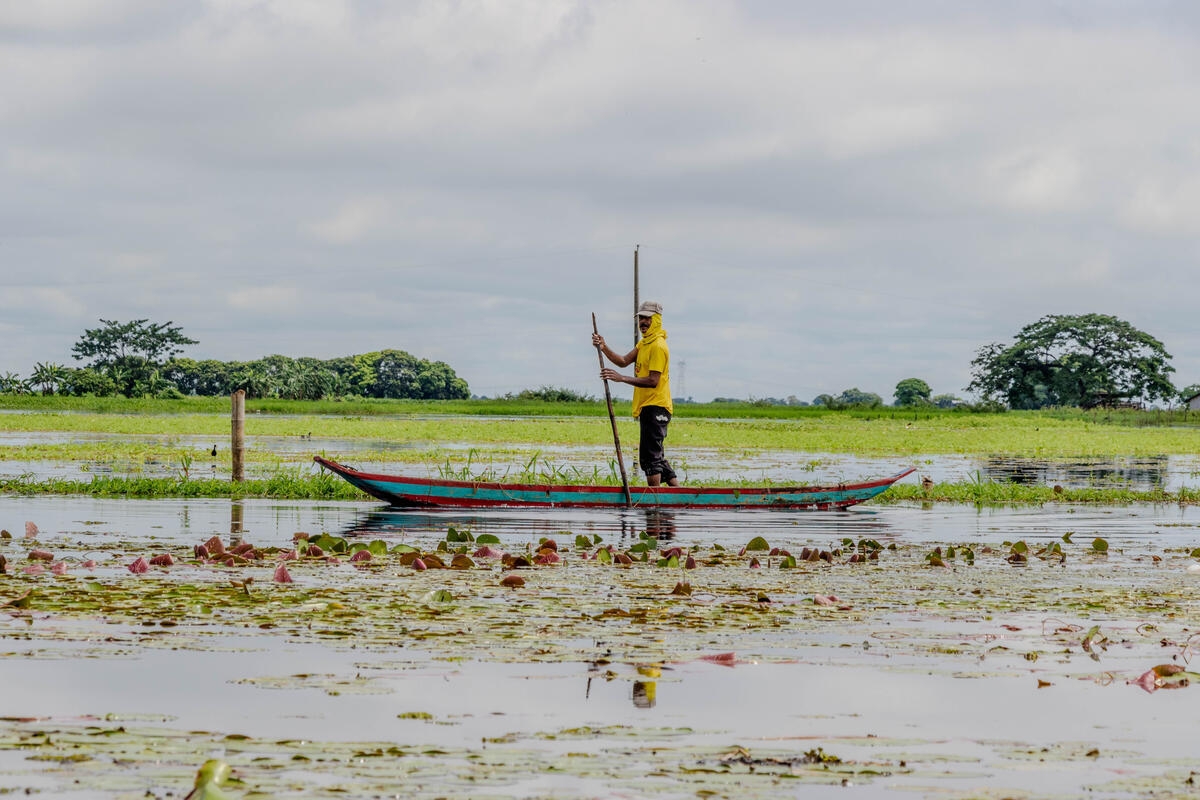 Julio Dominguez clears parts of the flood to reach his home by canoe in Ecuador. Photo: © WFP/Gonzalo Ruiz
