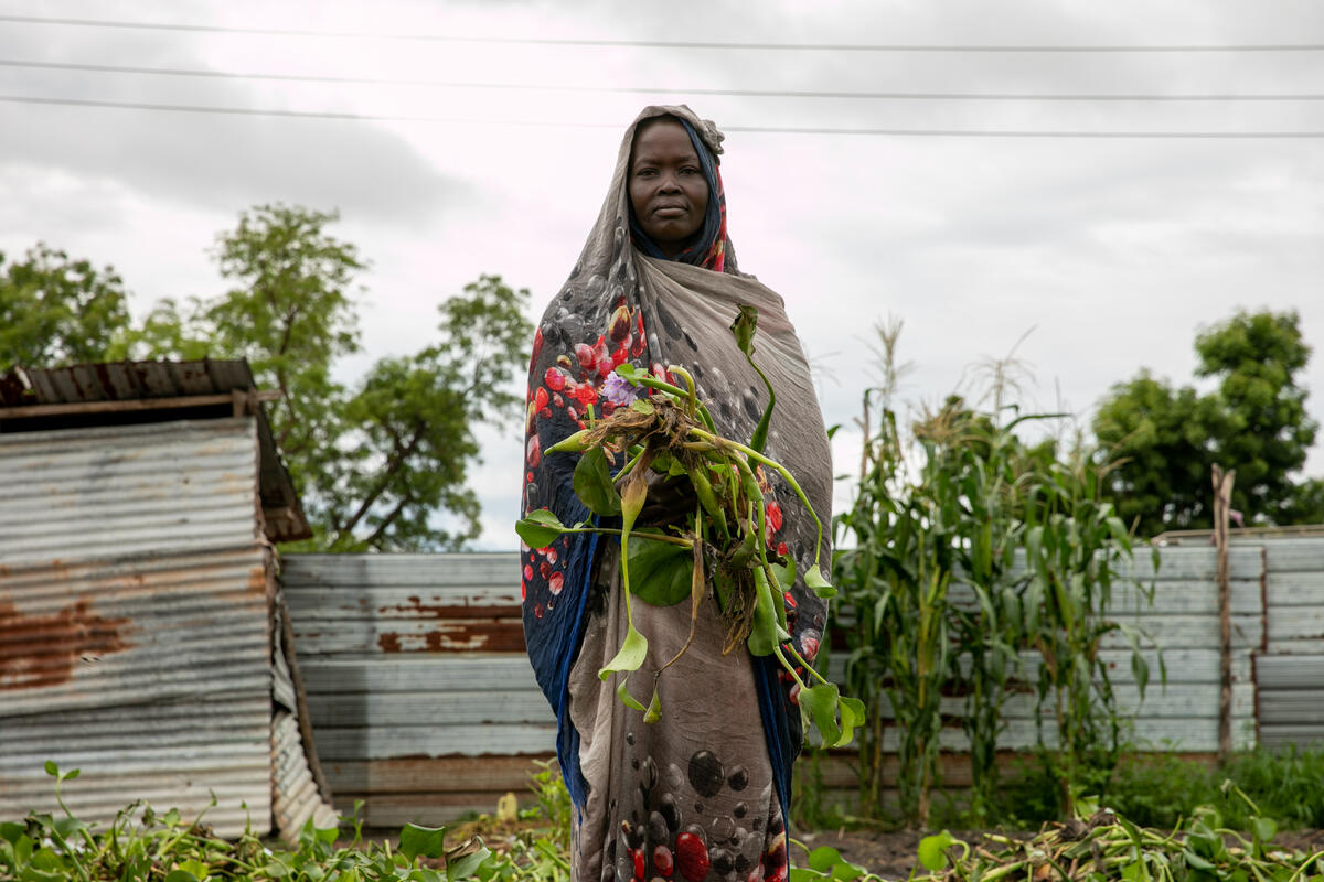 South Sudan. Nyayuit Gol drying water hyacinth in her house.