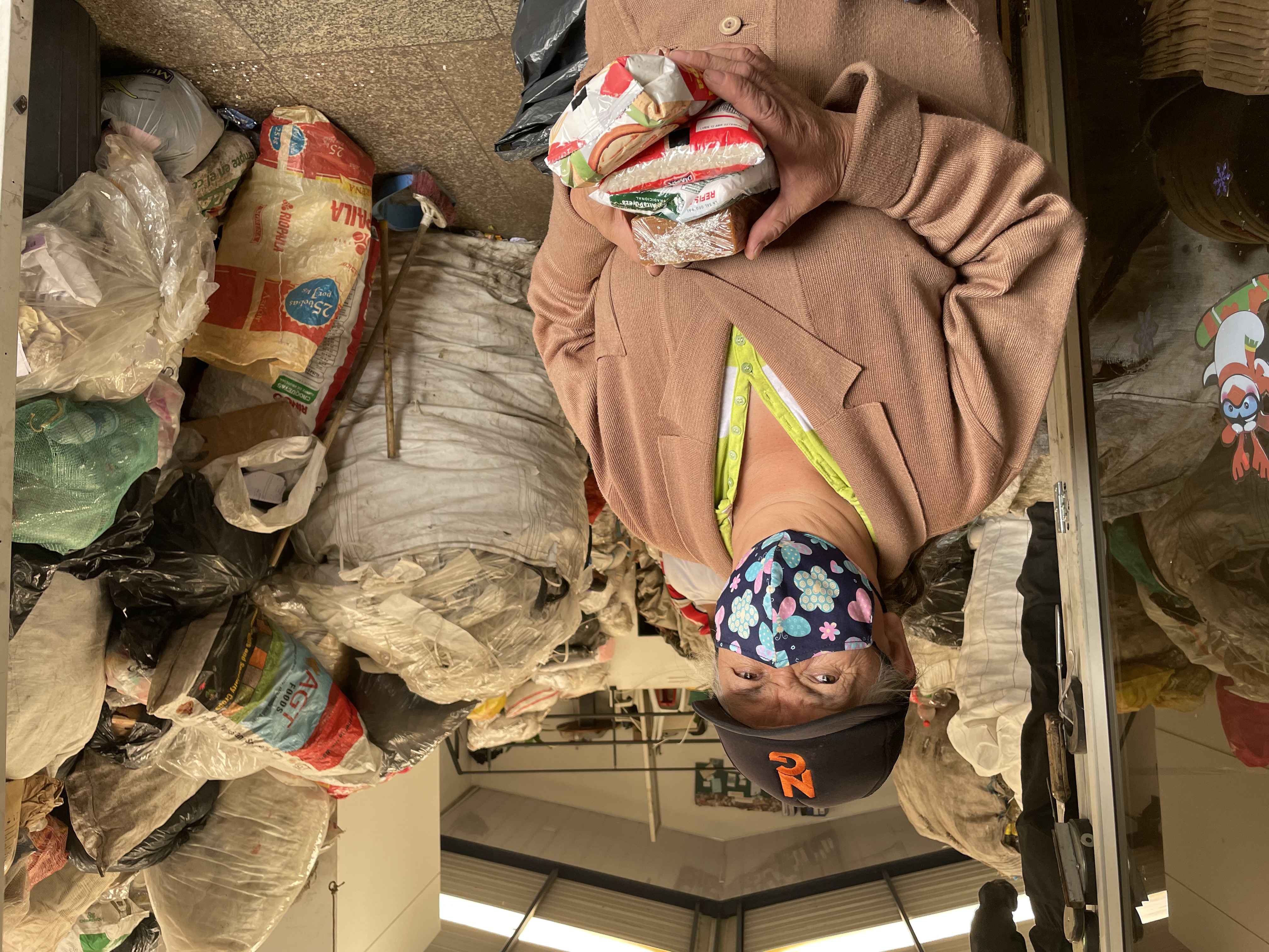 Woman in a shop, carrying food items exchanged for recyclable waste; Photo: WFP/Jessika Camargo