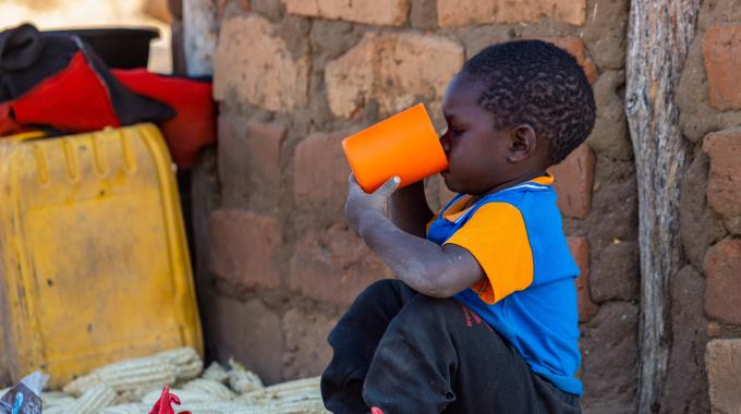 kid drinking water from cup