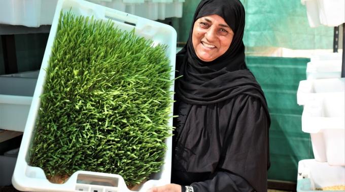A woman holds a plot of her hydroponic farming system