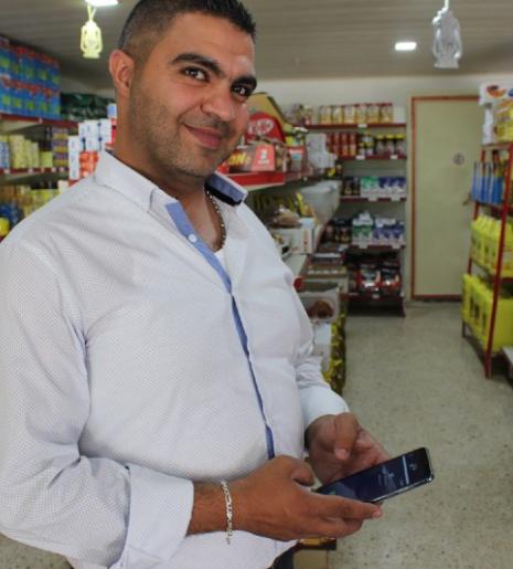 Omar, a shop owner, makes his store more attractive with Dalili