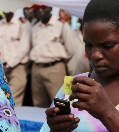 A woman redeems cash using mobile money cash top-up cards.