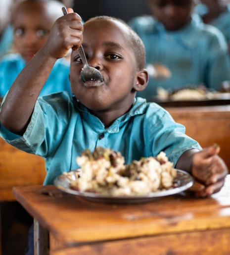 A student enjoying a plate of fortified maize meal with nutritious vegetable soup. Photo: © WFP/Isaac Onyango