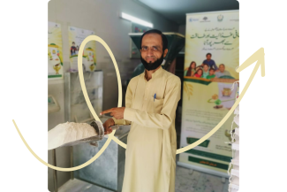 A man holds a scooper of Chakki nutritionally fortified flour.