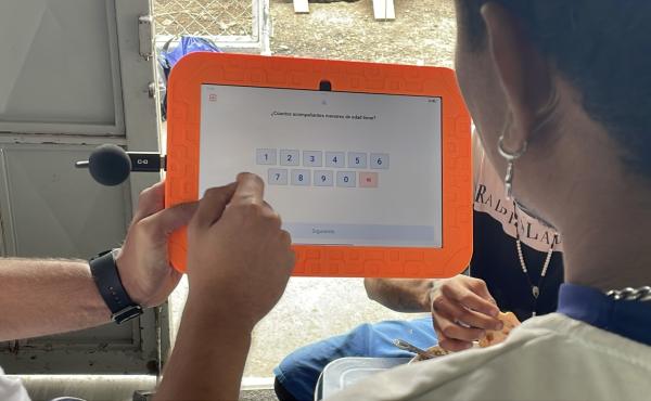 Una persona mostrando a otra como usar la tableta con Identi instalado. 