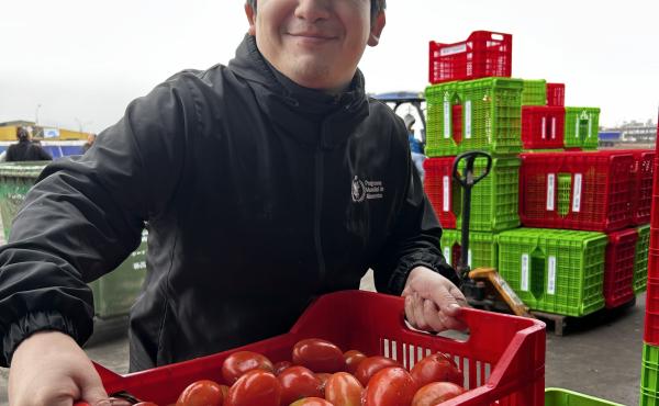 Un empleado de WFP con una caja de tomates