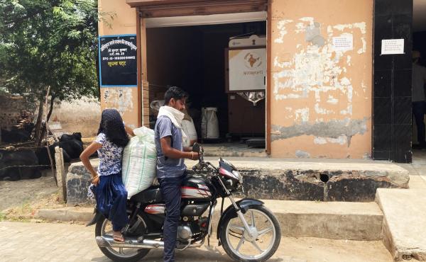 Couple on motorbike after using GrainATM to gather supplies.