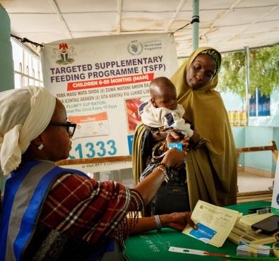 Woman delivering assistance via CODA to a woman and her child.