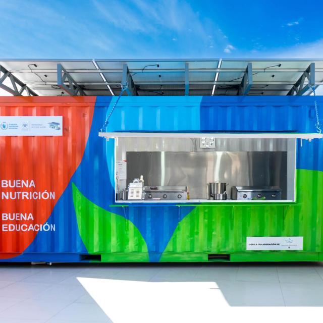 A brightly-colored storage container converted into a kitchen for delivering healthy school meals in El Salvador.