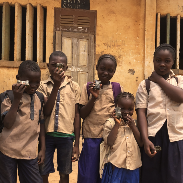 Children holding up Mbala Pinda snacks. Photo: WFP/Jose Shehata