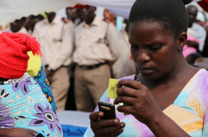 A woman redeems cash using mobile money cash top-up cards.