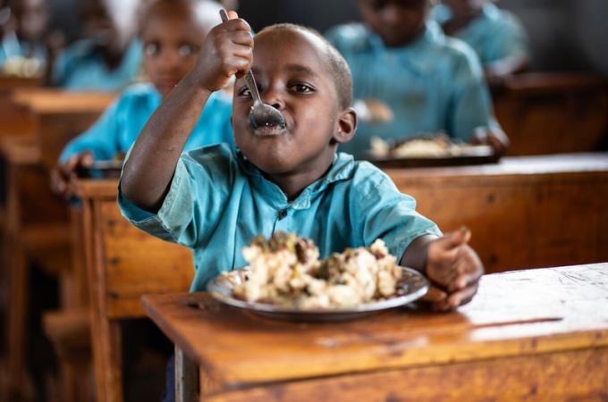 A student enjoying a plate of fortified maize meal with nutritious vegetable soup. Photo: © WFP/Isaac Onyango