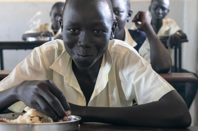 A boy eating lunch at his school desk. 