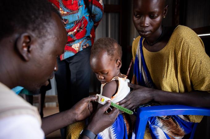 A young child has their arm measured as part of a nutrition data collection service.