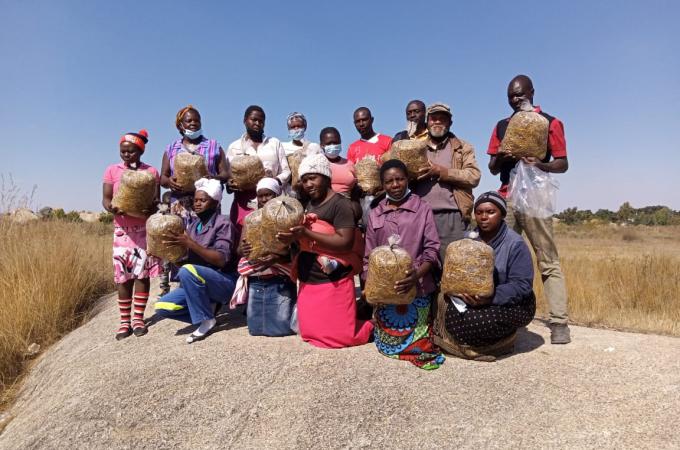 Project participants holding up bags of mushrooms